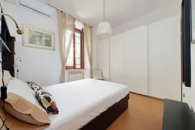 a white bedroom with a bed and a window at Viale Trastevere by Halldis in Rome