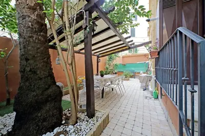 a patio with a tree and a table and chairs at Viale Trastevere by Halldis in Rome