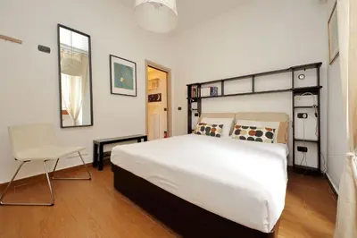 a bedroom with a large white bed and a chair at Viale Trastevere by Halldis in Rome