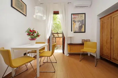 a dining room with a white table and yellow chairs at Viale Trastevere by Halldis in Rome