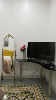a flat screen tv sitting on a table next to a mirror at Sweet Home Inn in Rome