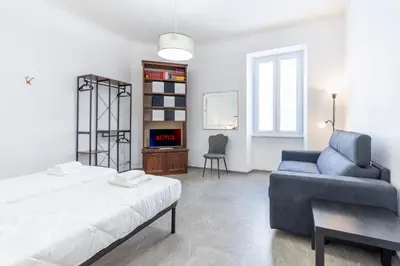 a bedroom with a bed and a couch and a chair at Vatican Essence in Rome