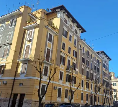 a yellow building with cars parked in front of it at Vatican Essence in Rome