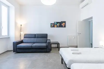 a bedroom with a blue couch and a bed at Vatican Essence in Rome