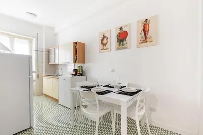 a white kitchen with a white table and chairs at A Casa di Nico - Metro B1 Conca d 'Oro in Rome