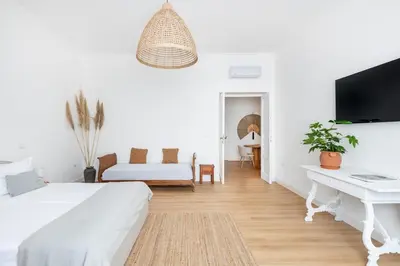a white living room with a bed and a desk at Davìta - Casa Leda in Rome