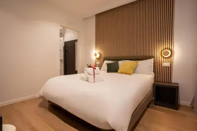 a bedroom with a large white bed and two lamps at Domus Augusti in Rome