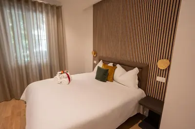 a bedroom with a large white bed with pillows at Domus Augusti in Rome