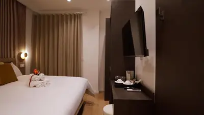 a hotel room with a bed and a flat screen tv at Domus Augusti in Rome