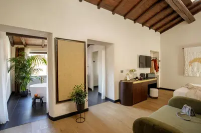 a living room with a couch and a bathroom at Daplace - Palazzo Serpe Suites near Colosseum in Rome