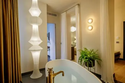 a bathroom with two lights above a bath tub at Daplace - Palazzo Serpe Suites near Colosseum in Rome