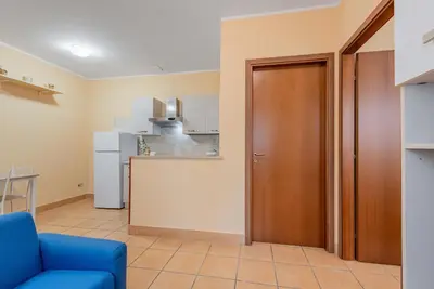 a living room with a blue couch and a kitchen at Casa Roma - La Casetta di Vale in Rome