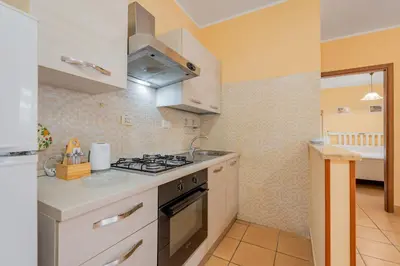 a kitchen with white cabinets and a stove top oven at Casa Roma - La Casetta di Vale in Rome