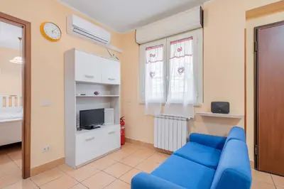 a living room with a blue couch and a tv at Casa Roma - La Casetta di Vale in Rome
