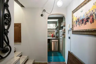 a hallway leading to a kitchen with a painting on the wall at Charming Pantheon Apt in the heart of Rome in Rome