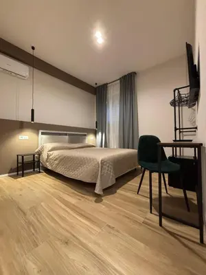 a bedroom with a bed and a chair and a desk at Eva suite in Rome