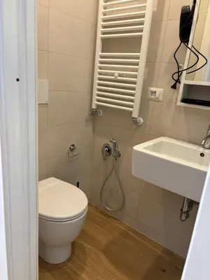 a bathroom with a toilet and a sink at Eva suite in Rome