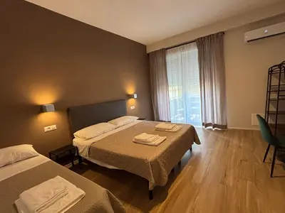 a hotel room with two beds and a window at Eva suite in Rome