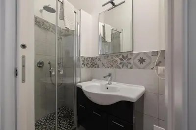 a bathroom with a sink and a glass shower at Santonofrio Apartments Silver e White in Rome