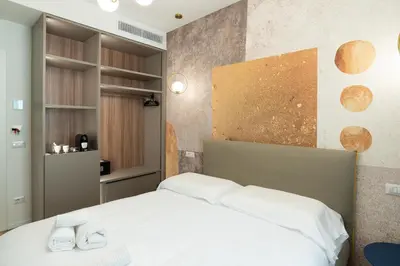 a bathroom with a toilet and a sink and a mirror at Maison Rasella Suites in Rome