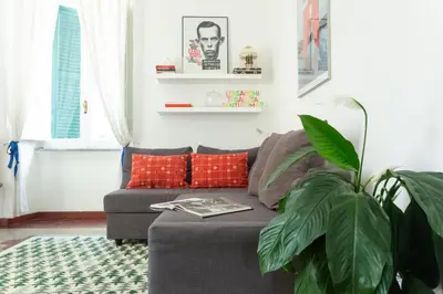 a living room with a gray couch and a plant at Vintage Vibes in Testaccio - Cale 07 in Rome