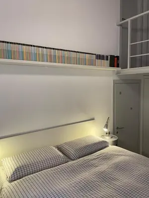 a bedroom with a bed with a shelf above it at Bollo flat in Rome