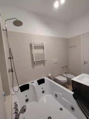 a white bathroom with a tub and a toilet at Sweet Home in Rome