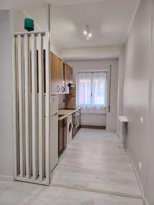 an empty kitchen with a refrigerator and a window at Sweet Home in Rome