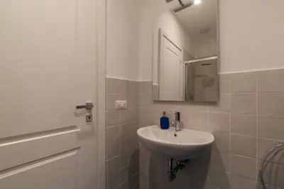 a white bathroom with a sink and a mirror at GuestHost - Charming Apartment Metro Cipro in Rome