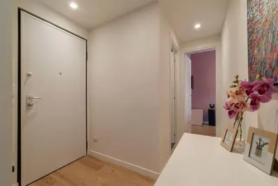 a hallway with a white door and a vase of flowers at GuestHost - Charming Apartment Metro Cipro in Rome