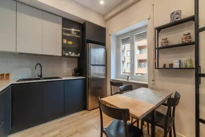 a kitchen with a table and a refrigerator at GuestHost - Charming Apartment Metro Cipro in Rome
