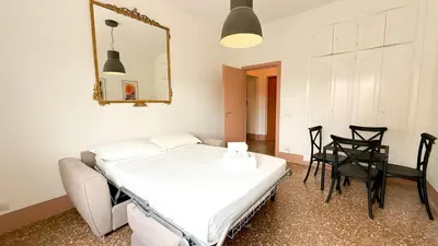 a bedroom with a bed and a table and a mirror at Stylish Apt Balcony, AC,Aqueduct View in Rome
