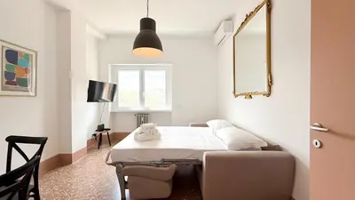 a bedroom with a bed and a mirror and a window at Stylish Apt Balcony, AC,Aqueduct View in Rome