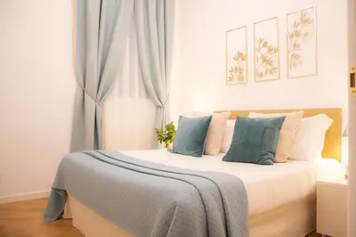 a bedroom with a white bed with blue pillows at La Veranda dei Farnesi in Rome