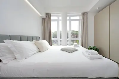 a white bed with white pillows and a window at Luminoso appartamento di fronte Metro Piramide in Rome