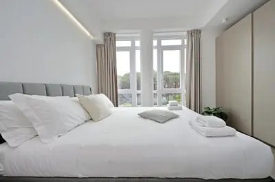 a bedroom with a large white bed with a window at Luminoso appartamento di fronte Metro Piramide in Rome