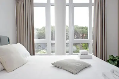 a bedroom with a white bed with a large window at Luminoso appartamento di fronte Metro Piramide in Rome