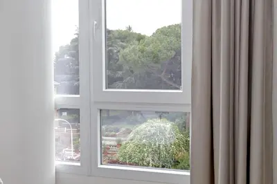 a window with a view of a garden at Luminoso appartamento di fronte Metro Piramide in Rome