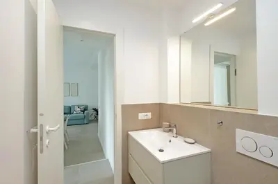 a white bathroom with a sink and a mirror at Luminoso appartamento di fronte Metro Piramide in Rome