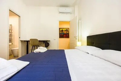 a bedroom with a large bed with a blue blanket at Paruta Rooms 22 in Rome