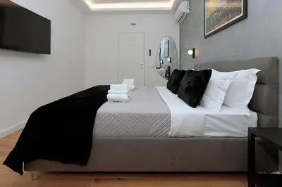 a bedroom with a large bed with black and white pillows at Malva Suite in Rome