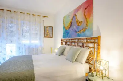 a bedroom with a white bed and a painting on the wall at Vacanze Romane in Rome