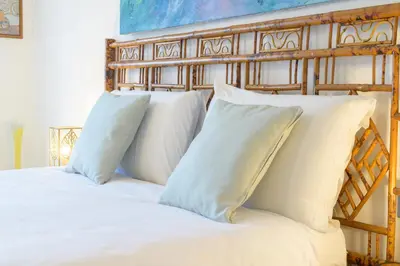 a bed with white pillows and a wooden headboard at Vacanze Romane in Rome