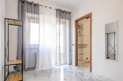 a room with white curtains and a mirror at Vacanze Romane in Rome