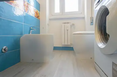 a bathroom with a toilet and a washing machine at Vacanze Romane in Rome