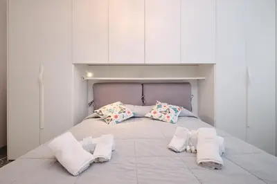 a bed with three pillows on it in a room at Residenza Lucis - Camillo Hospital - Monteverde by Hôtea in Rome