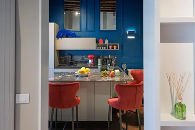 a kitchen with blue cabinets and red bar stools at Dreamers in Belsiana Spagna int 8 in Rome