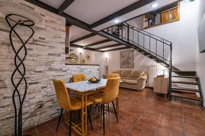 a living room with a table and chairs and a staircase at Domus Campo de Fiori in Rome