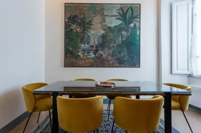 a dining room table with yellow chairs and a painting at MyRentalInn Scarlatti Rhome Parioli in Rome