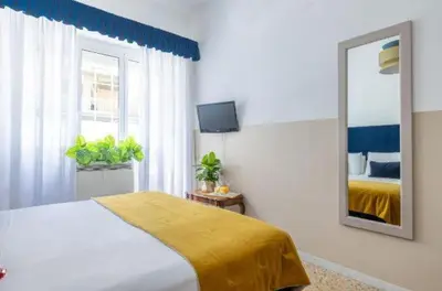 a bedroom with a bed and a mirror and a window at Next Stop Vatican Guest House in Rome